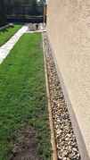 Stav před instalací, v sousedství nasákavého betonového obrubníku je patrná linie trávníkových rostlin buď již uschlých, nebo trpících nedostatkem vody a živin